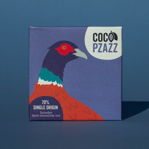 Bar of Coco Pzazz Ecuador Dark Chocolate, it has a blue wrapper with an illustration of a pheasant, it is placed on a blue background.